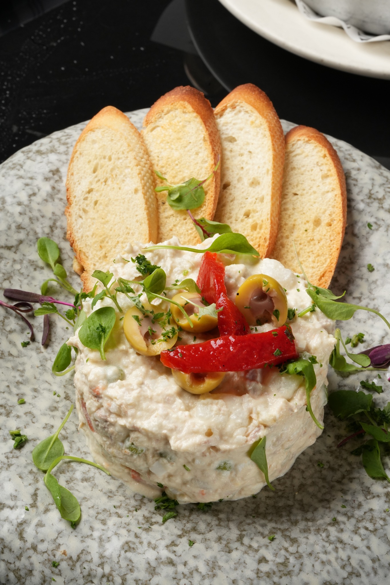 Xixón house ensaladilla with olives, roasted peppers, herbs, and toasted bread